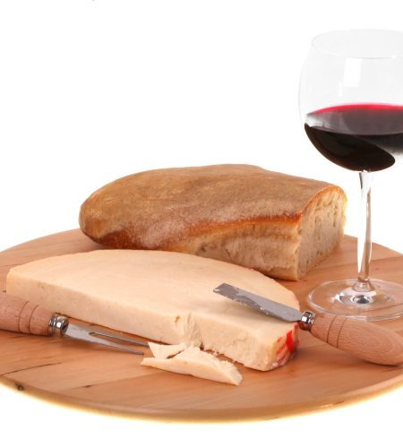 Italian spicy provolone cheese with red wine and bread on white background